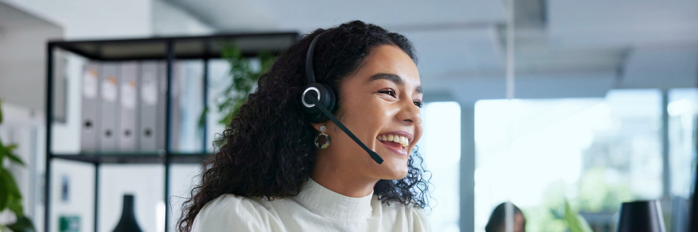 Eine junge Frau telefoniert ĂĽber ein Headset