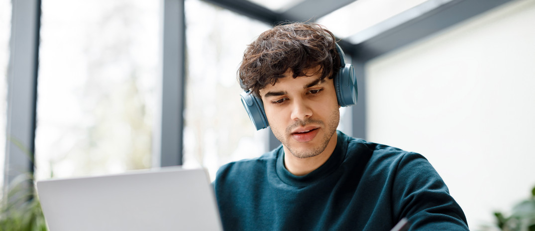Ein junger Mann sitzt am Laptop