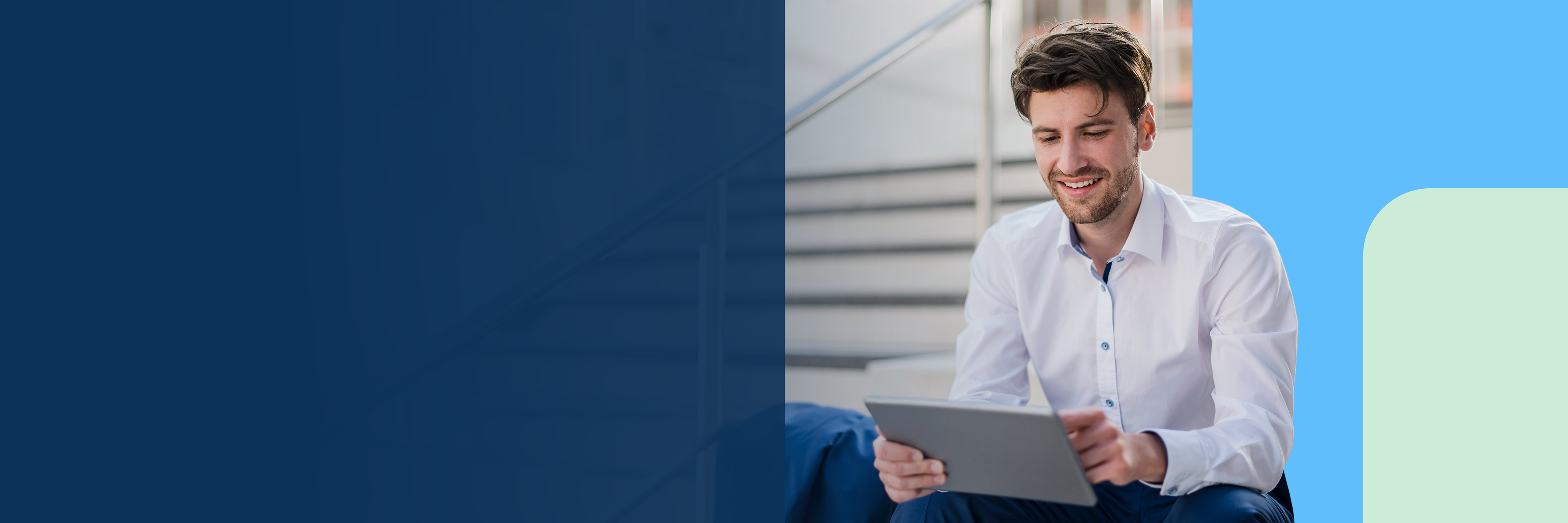 Ein junger Mann sitz auf einer Treppe mit einem Tablet.